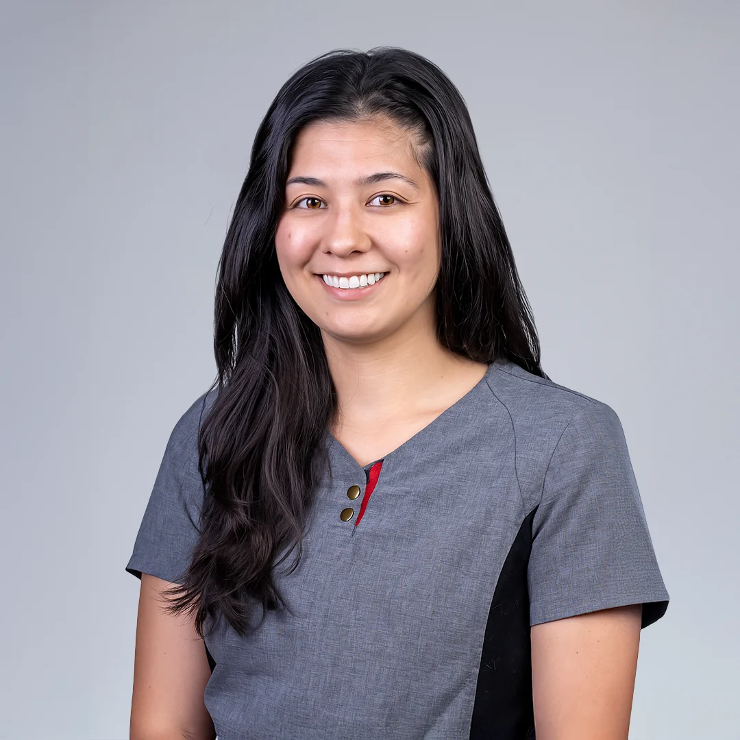 Person in gray outfit, neutral background.