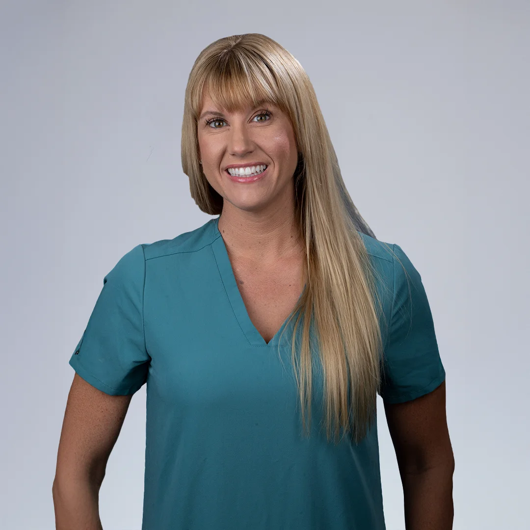 Person in teal shirt, neutral background.