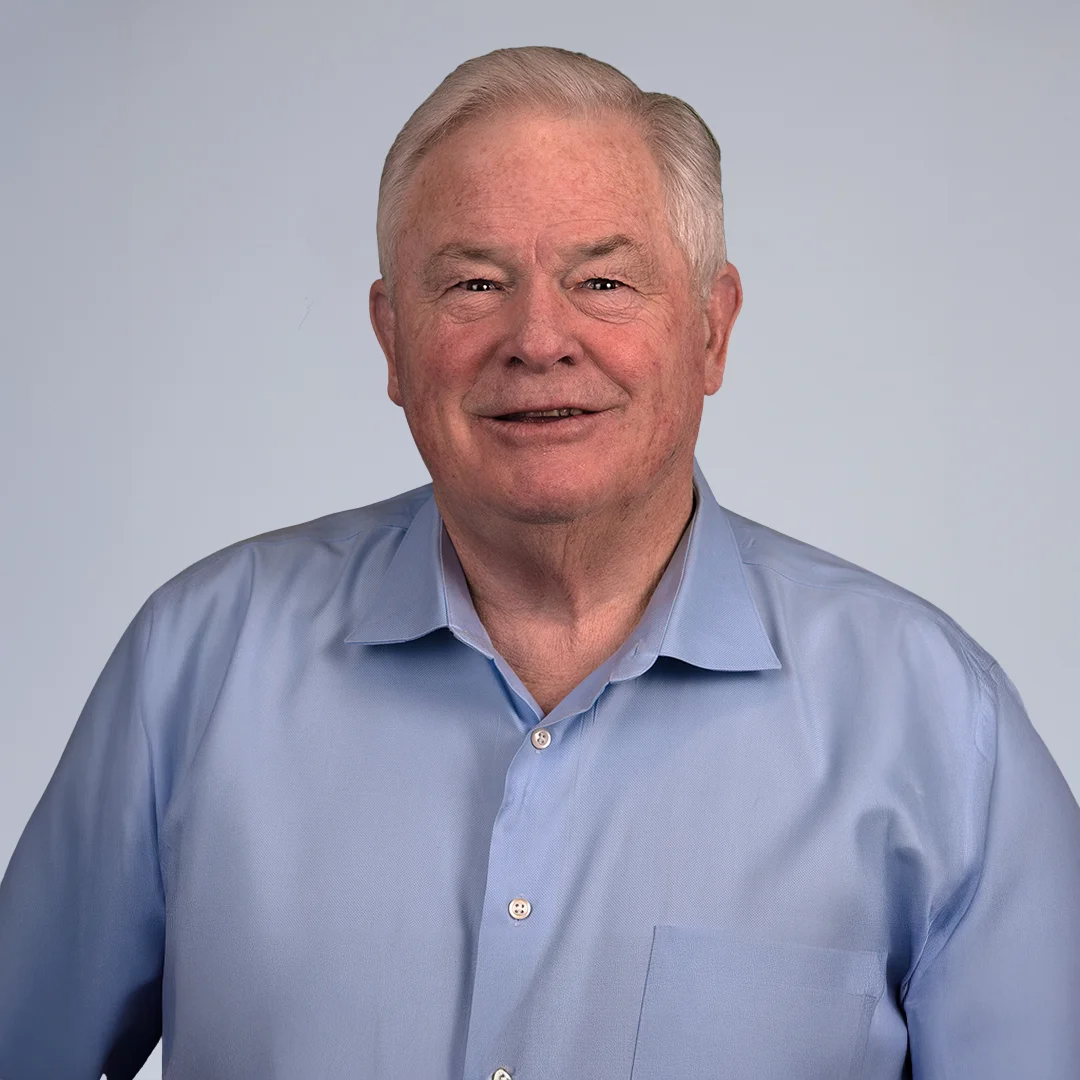 Man in blue shirt, neutral background.