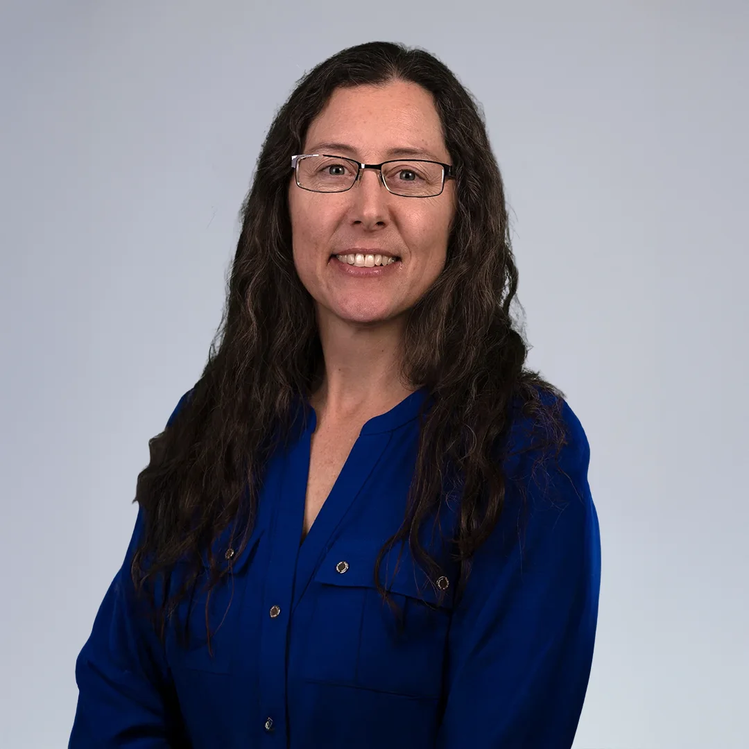 Person in blue shirt, neutral background.