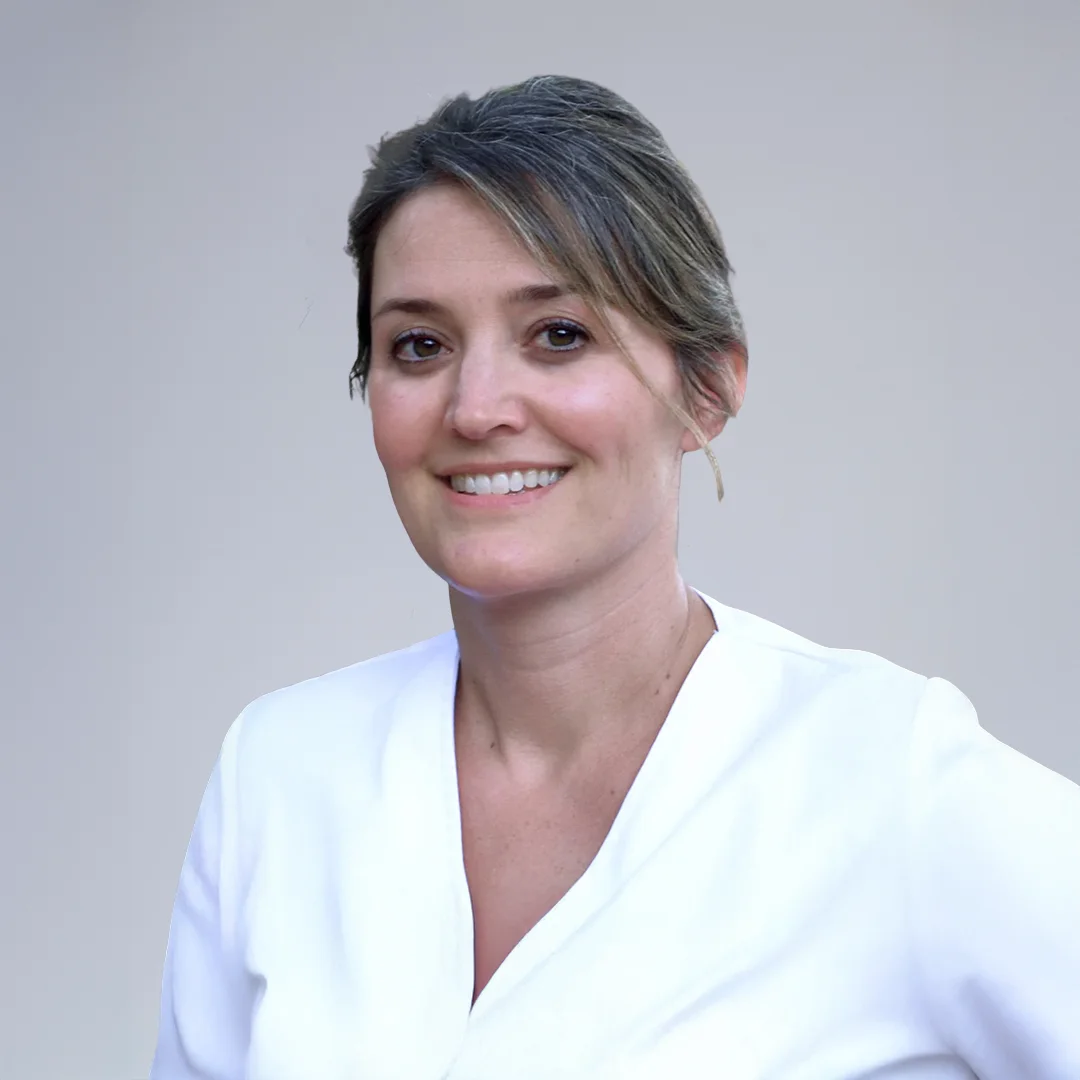 Person in white attire, neutral background.