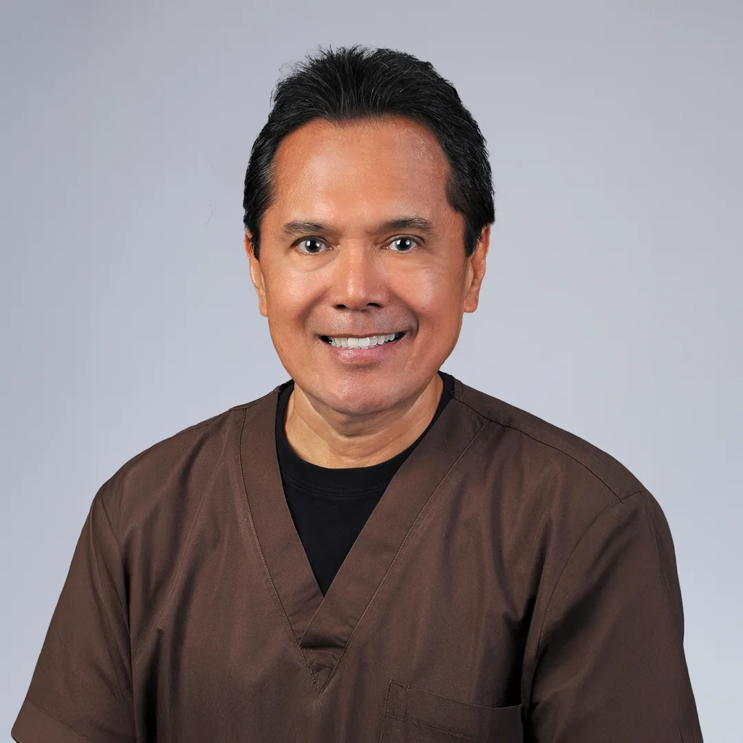 Person in medical scrubs, neutral background.