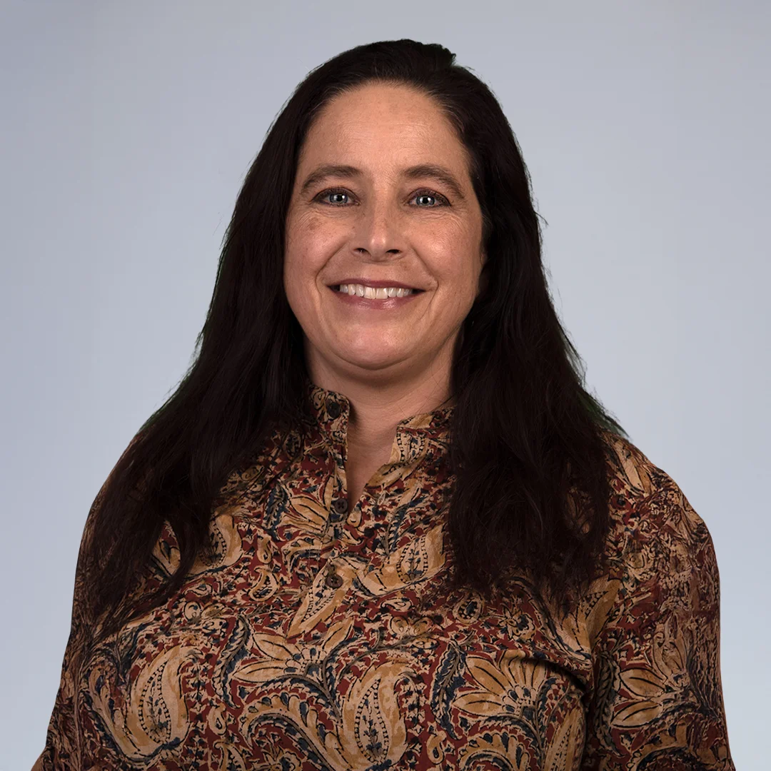 Person in patterned shirt, neutral background.